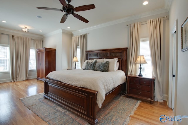 bedroom featuring multiple windows, ornamental molding, and light wood finished floors