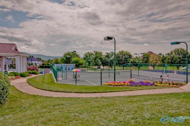 view of sport court with a yard and fence