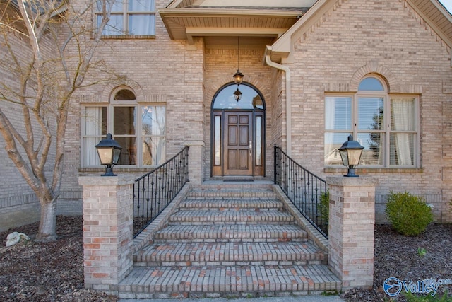 view of exterior entry featuring brick siding