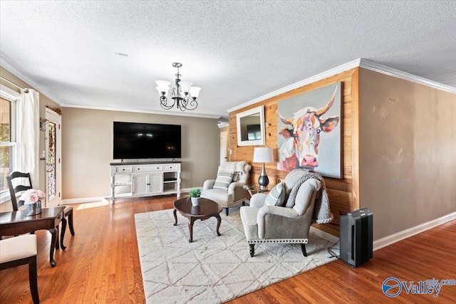 living room with a textured ceiling, wood-type flooring, and crown molding