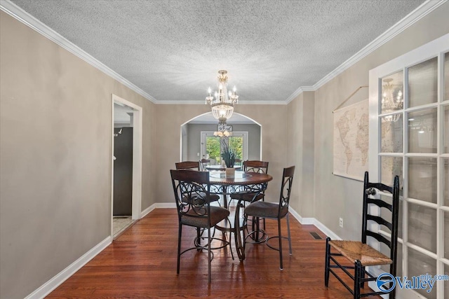 dining space featuring ornamental molding, a chandelier, a textured ceiling, and dark hardwood / wood-style flooring