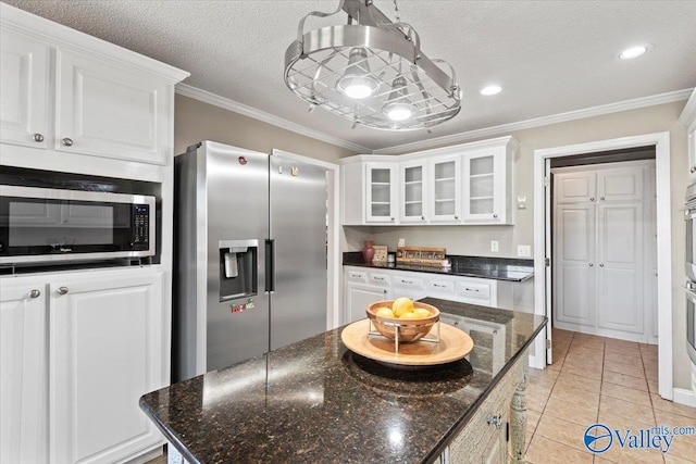 kitchen featuring white cabinets, a textured ceiling, stainless steel appliances, and ornamental molding