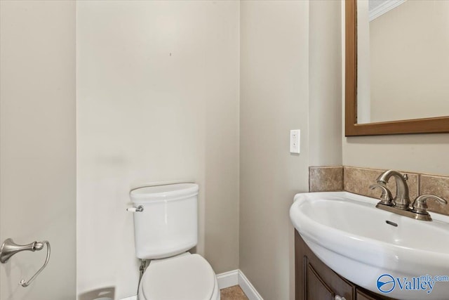 bathroom featuring crown molding, vanity, and toilet