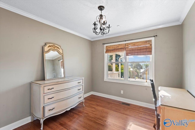 home office featuring an inviting chandelier, ornamental molding, a textured ceiling, and dark wood-type flooring