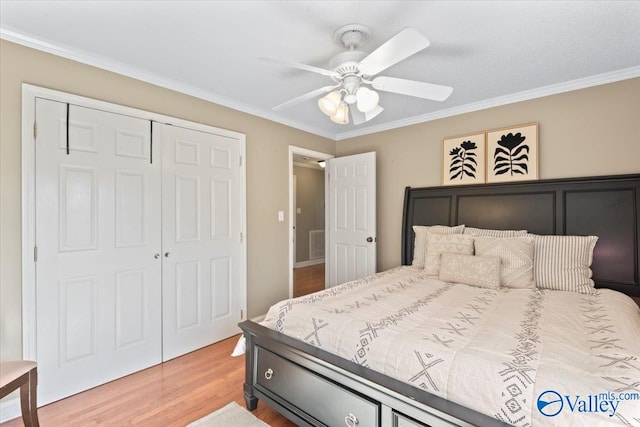 bedroom featuring ceiling fan, a closet, ornamental molding, and wood-type flooring