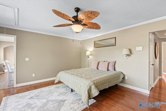 bedroom with ceiling fan, hardwood / wood-style flooring, ornamental molding, and a textured ceiling