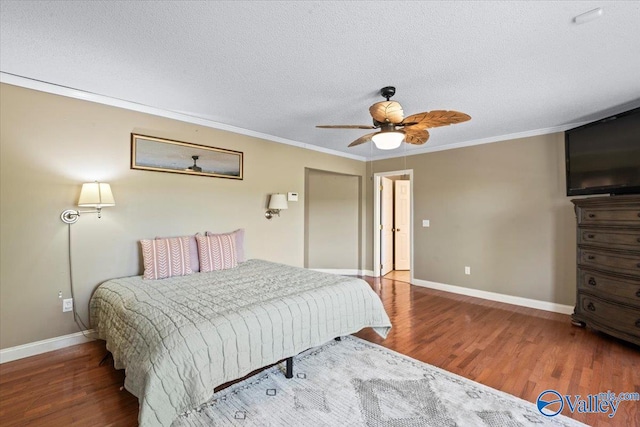 bedroom with ornamental molding, wood-type flooring, ceiling fan, and a textured ceiling