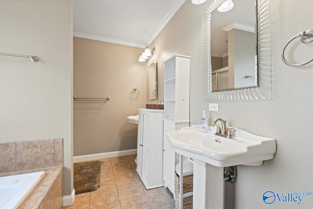 bathroom featuring tile patterned flooring, a textured ceiling, sink, ornamental molding, and tiled bath