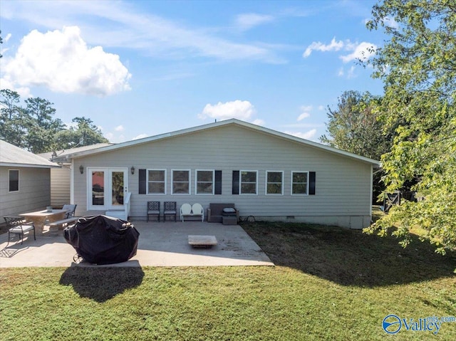 rear view of property with a fire pit, a yard, and a patio area