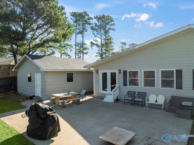 rear view of property featuring a patio and an outbuilding