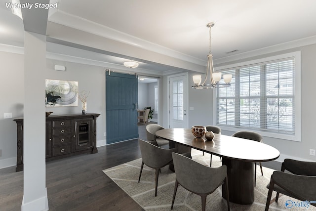 dining room featuring dark hardwood / wood-style flooring, a barn door, and ornamental molding