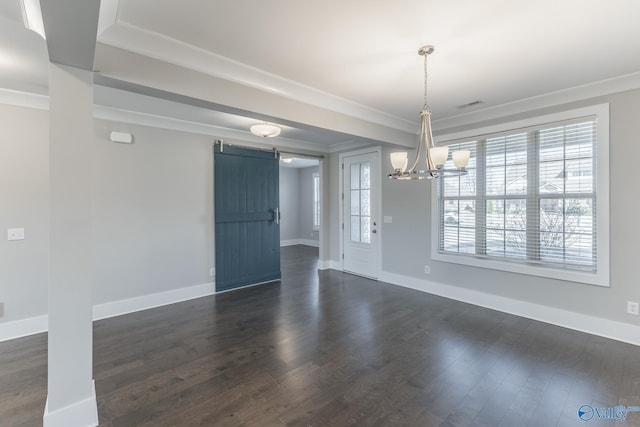 unfurnished dining area with dark hardwood / wood-style floors, a barn door, ornamental molding, and an inviting chandelier