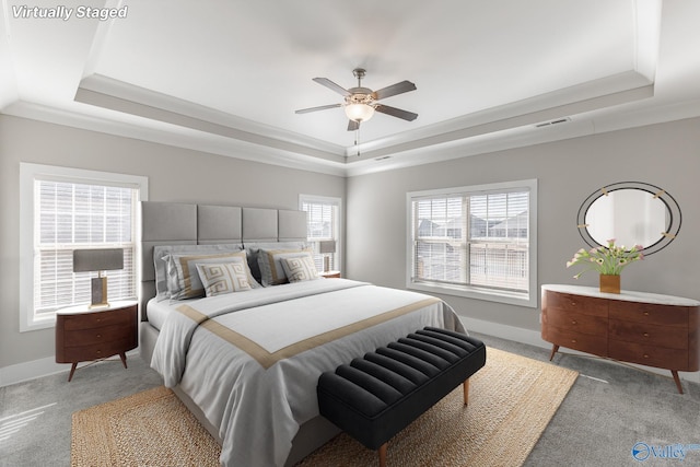 bedroom featuring a raised ceiling, ceiling fan, light carpet, and ornamental molding