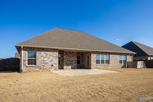 rear view of house with a lawn and a patio