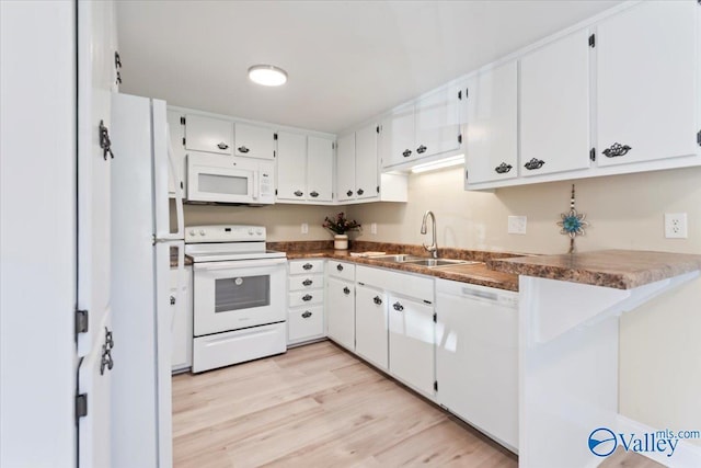 kitchen with white cabinetry, sink, kitchen peninsula, white appliances, and light wood-type flooring