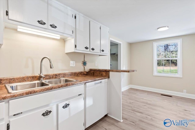 kitchen with white cabinets, white dishwasher, light hardwood / wood-style floors, and sink