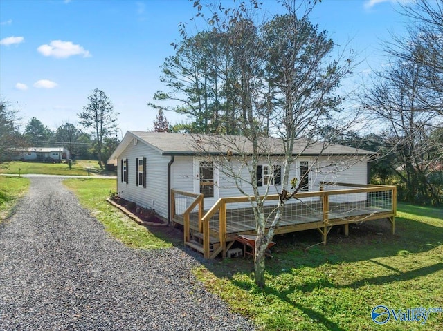 rear view of property featuring a deck and a lawn