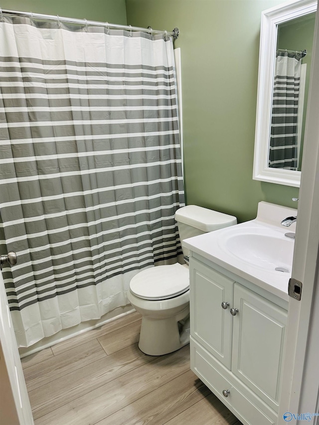 bathroom with vanity, curtained shower, wood-type flooring, and toilet