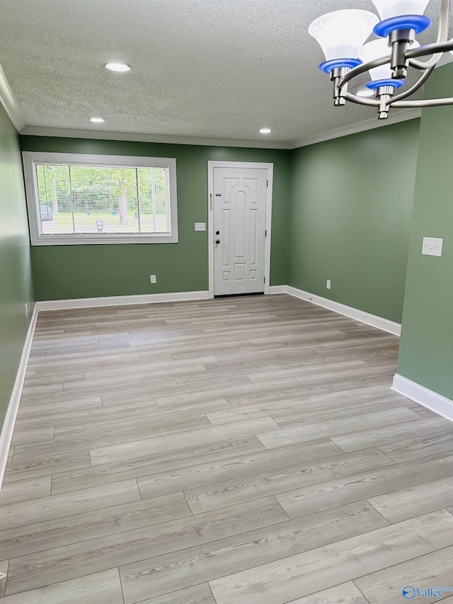 interior space featuring a textured ceiling, light hardwood / wood-style flooring, and a chandelier