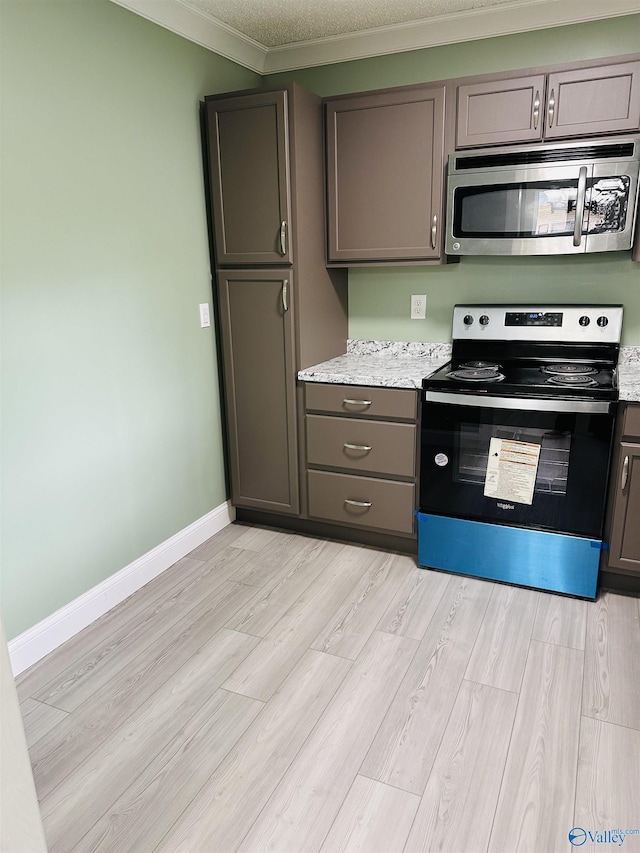 kitchen featuring ornamental molding, light hardwood / wood-style floors, stainless steel appliances, light stone countertops, and a textured ceiling