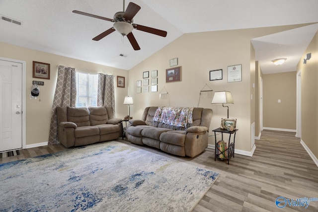 living room with ceiling fan, wood-type flooring, a textured ceiling, and vaulted ceiling