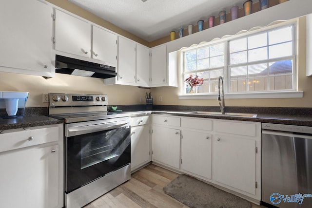 kitchen with sink, light wood-type flooring, a textured ceiling, appliances with stainless steel finishes, and white cabinetry