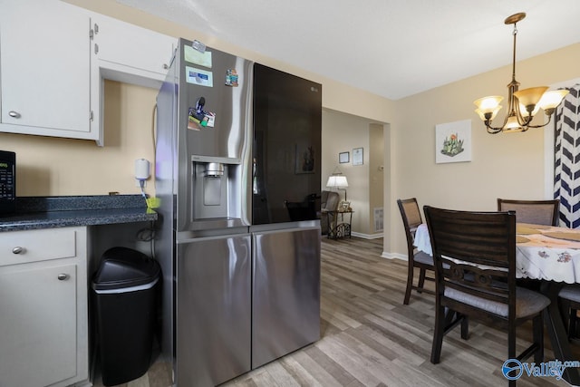 kitchen with a notable chandelier, white cabinetry, stainless steel refrigerator with ice dispenser, and light hardwood / wood-style flooring