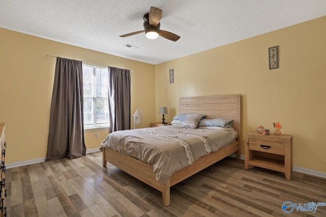 bedroom with a textured ceiling, hardwood / wood-style flooring, and ceiling fan