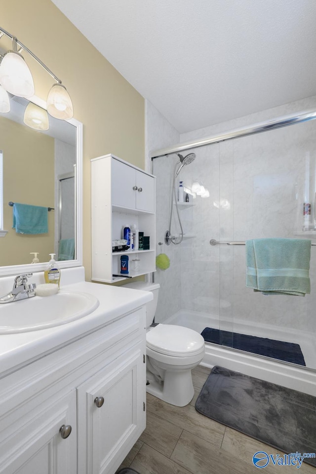 bathroom with vanity, an enclosed shower, and toilet