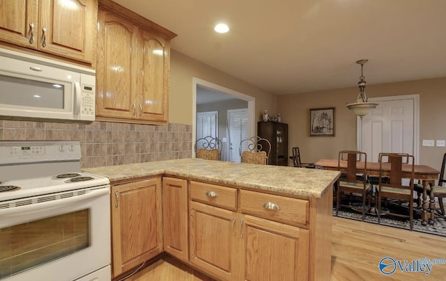 2220 Jefferson St, Courtland, AL 35618 - kitchen featuring white appliances, a peninsula, light countertops, light wood finished floors, and decorative backsplash