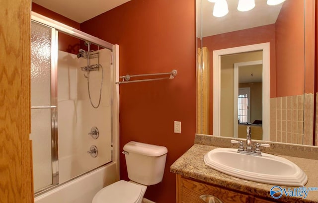 full bathroom featuring enclosed tub / shower combo, vanity, and toilet