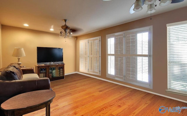 living room with ceiling fan and light wood-type flooring