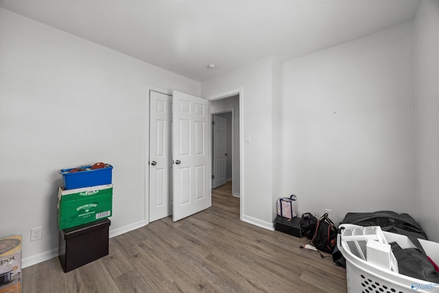 bedroom featuring wood finished floors and baseboards