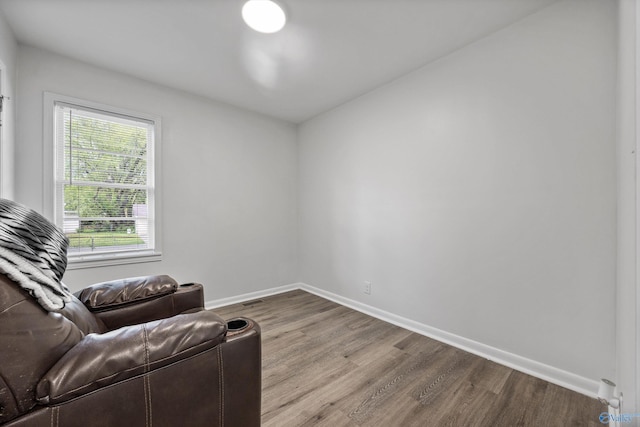 sitting room with baseboards and wood finished floors