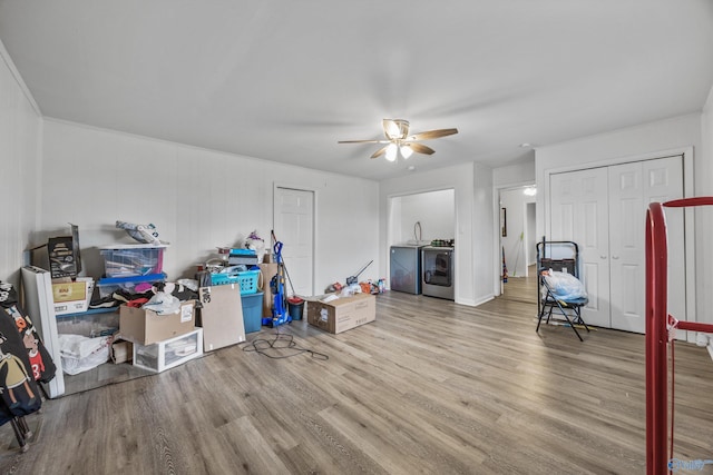 interior space with a ceiling fan, separate washer and dryer, and wood finished floors