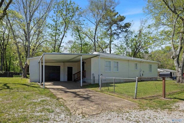manufactured / mobile home featuring a detached garage, fence, a front lawn, and driveway