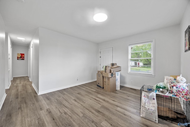 misc room with baseboards, visible vents, and wood finished floors