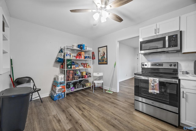 kitchen with baseboards, stainless steel appliances, ceiling fan, and wood finished floors