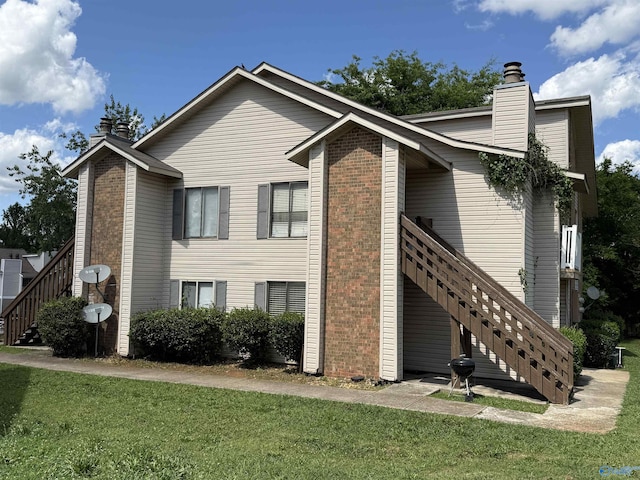 2222 SW Wind Trace Cir, Huntsville, AL 35805 - view of home's exterior with a chimney, stairs, and a yard