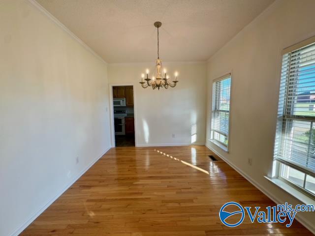 17215 Eunice Ln, Athens, AL 35613 - unfurnished dining area featuring a chandelier, wood finished floors, baseboards, and ornamental molding