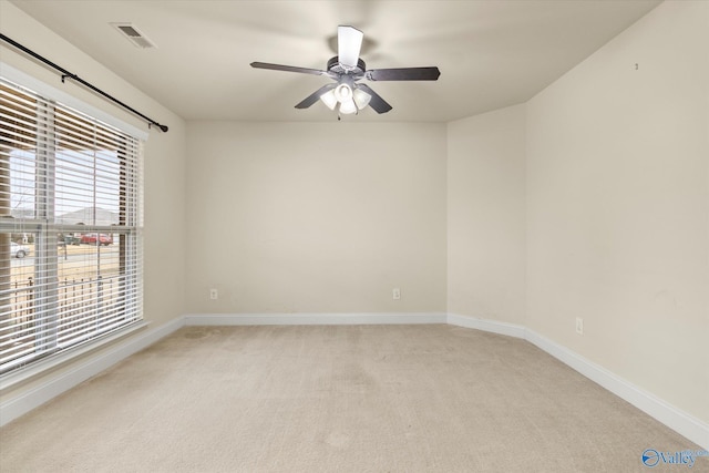 spare room with ceiling fan and light colored carpet