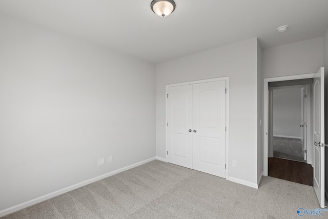 unfurnished bedroom with a closet and light carpet