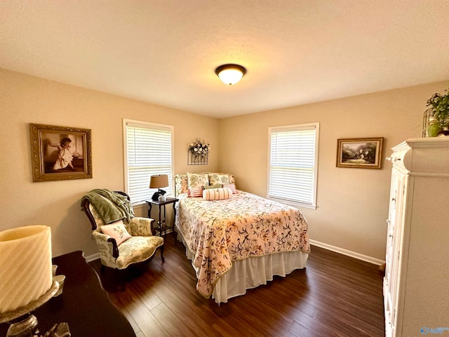 bedroom with a textured ceiling and dark hardwood / wood-style flooring