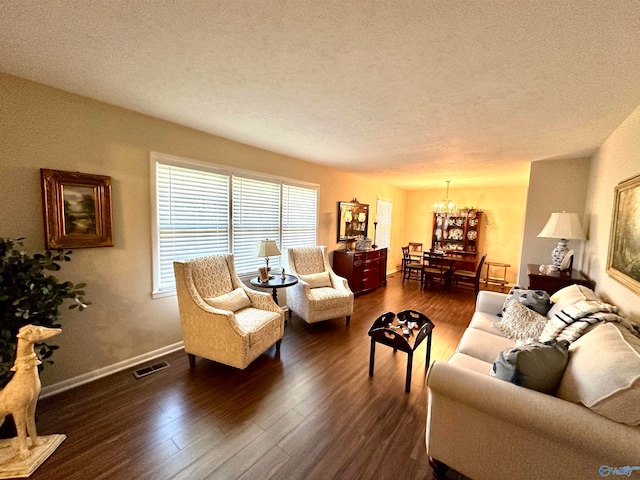 living room featuring a chandelier, a textured ceiling, and dark hardwood / wood-style floors