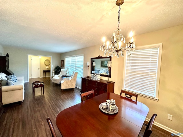 dining space with an inviting chandelier, a textured ceiling, and dark wood-type flooring