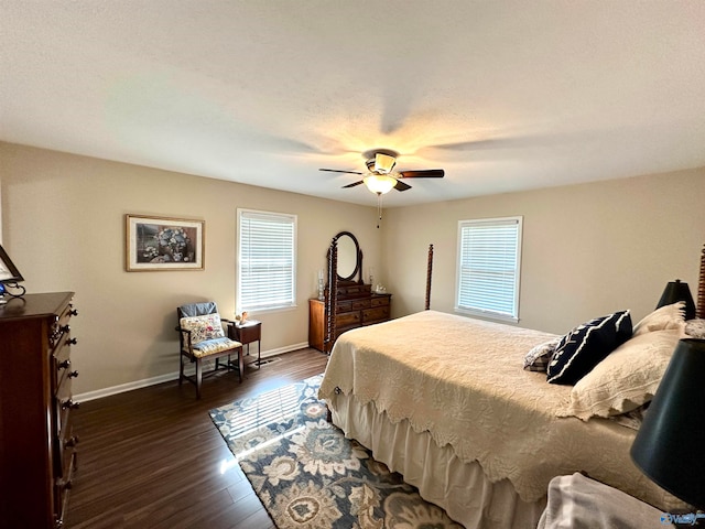 bedroom with a textured ceiling, dark wood-type flooring, and ceiling fan