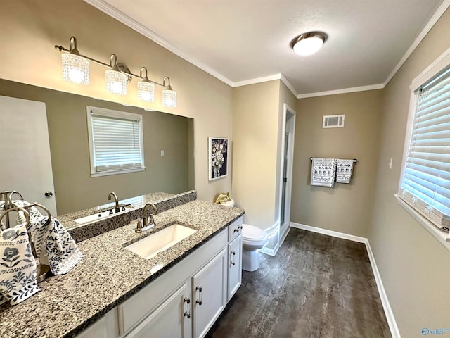 bathroom with hardwood / wood-style floors, crown molding, vanity, and toilet