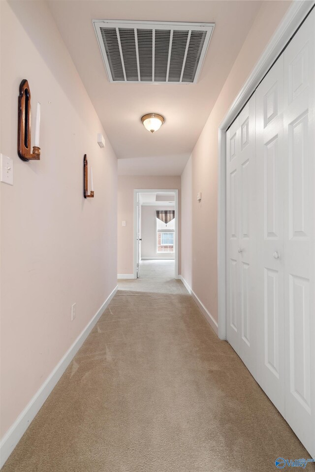 hallway with light carpet and baseboards