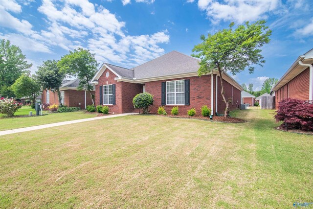 ranch-style home with brick siding, a front yard, and central AC