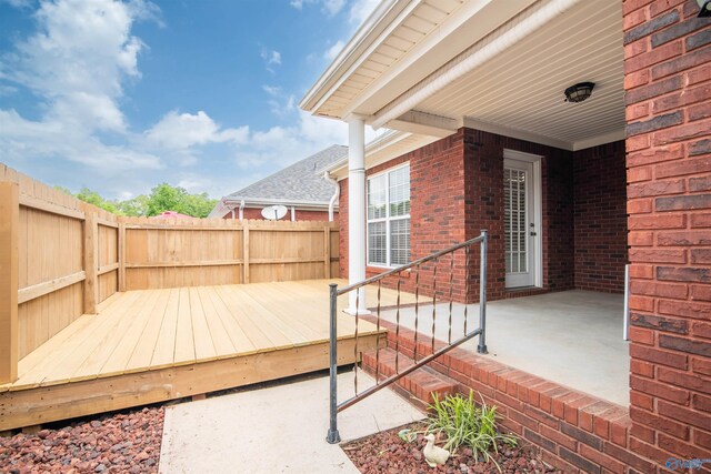 wooden deck with a fenced backyard and a patio area